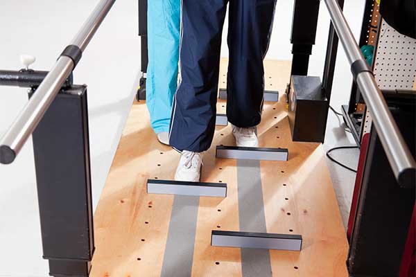 Physical therapist helping patient through gait training.