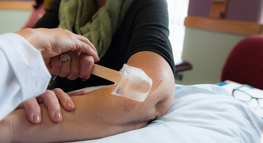 Physical therapist applying ice to patient's arm