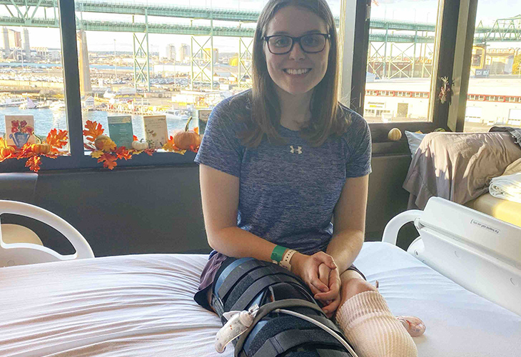 Morgan sitting in her hospital bed, wearing her prosthetic legs.